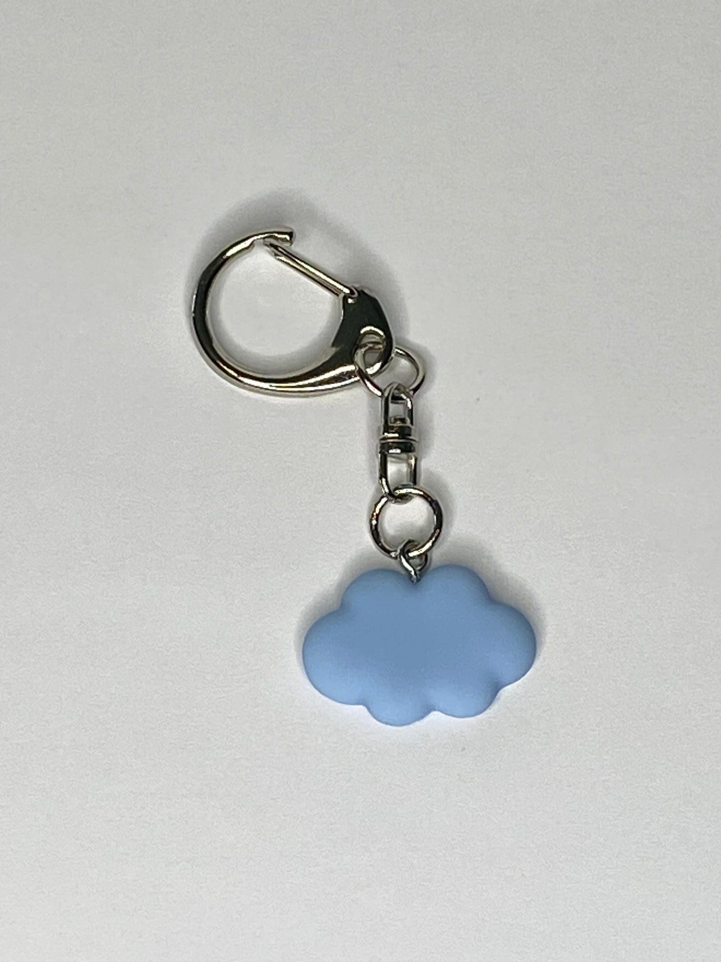 Keychain with a blue cloud-shaped charm on a light gray background