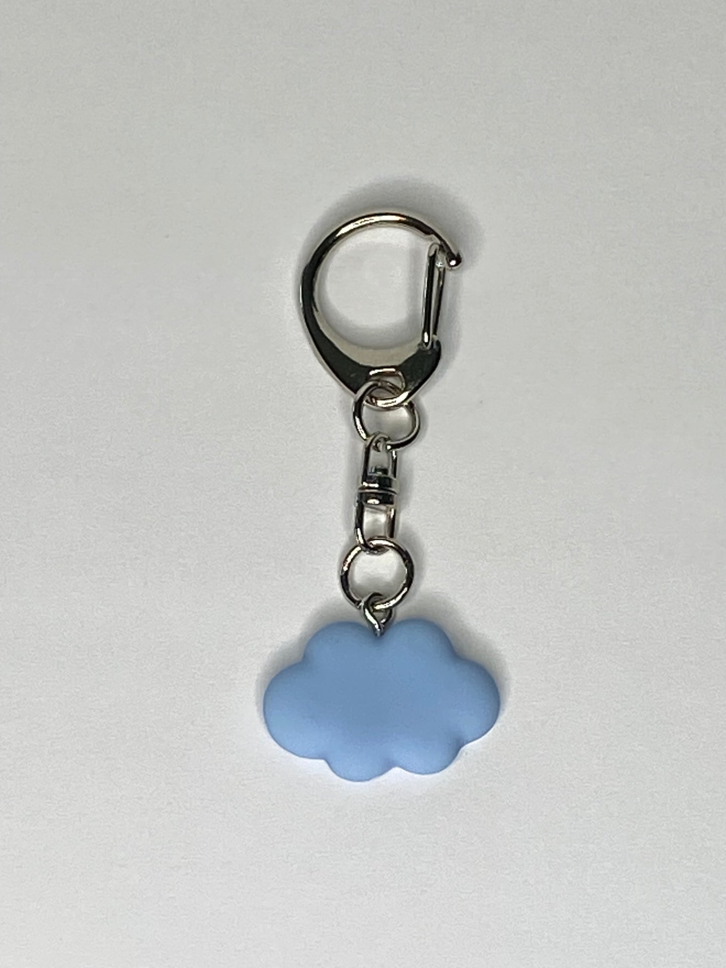 Keychain with a blue cloud-shaped charm on a light gray background