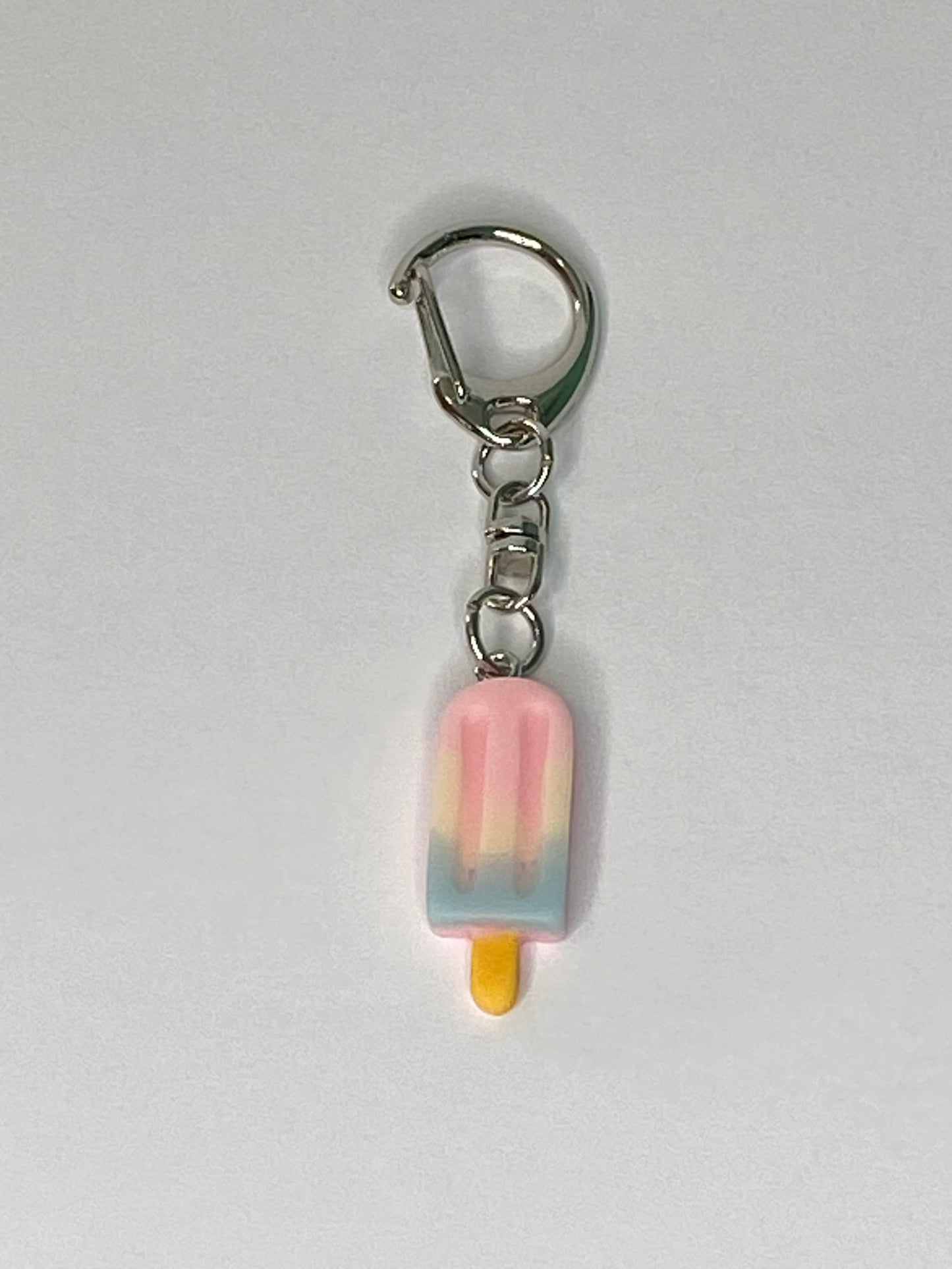 Keychain with a pink popsicle-shaped charm on a light gray background