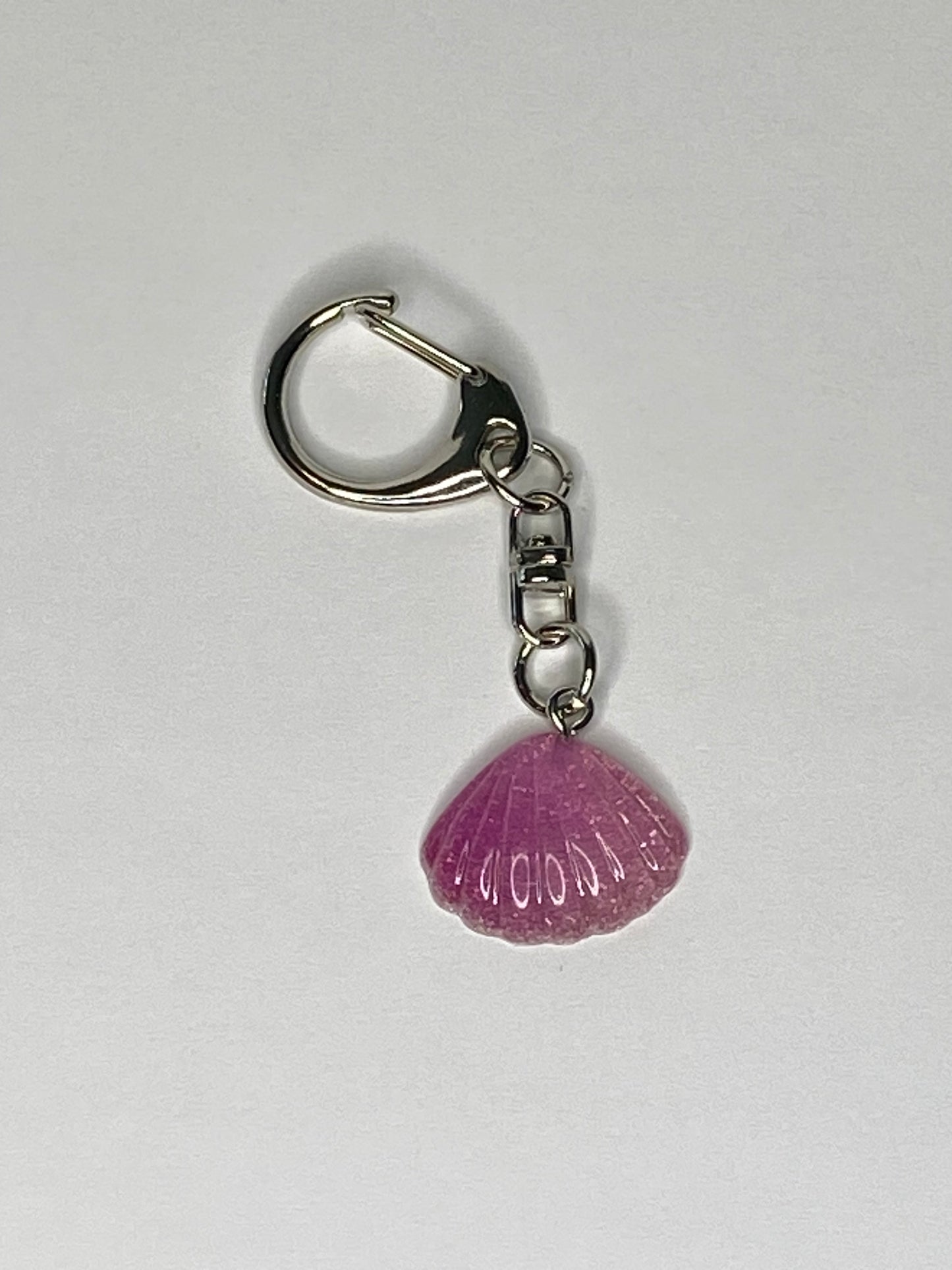 Keychain with a violet seashell charm on a white background