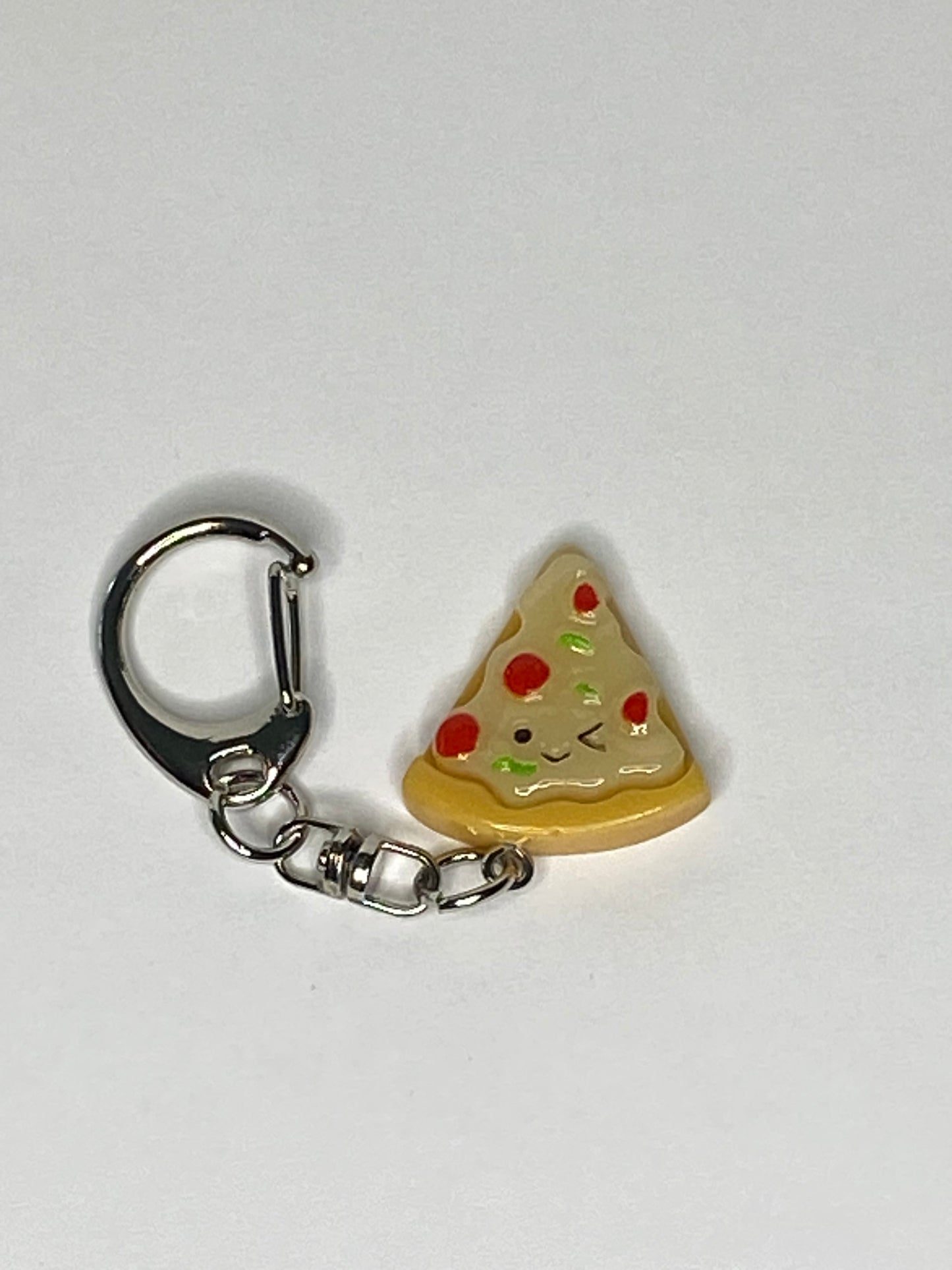 Pizza slice keychain with a smiling face on a white background