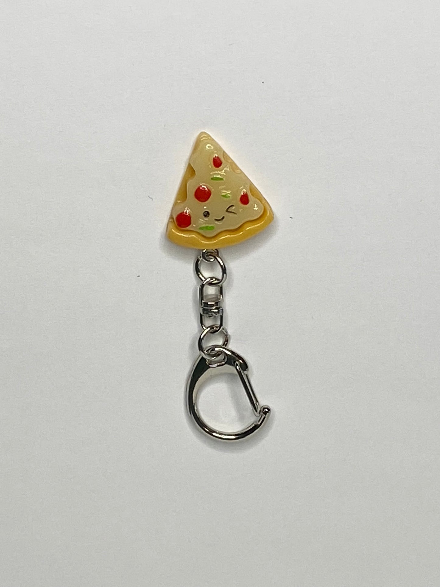 Pizza slice keychain with a smiling face on a white background