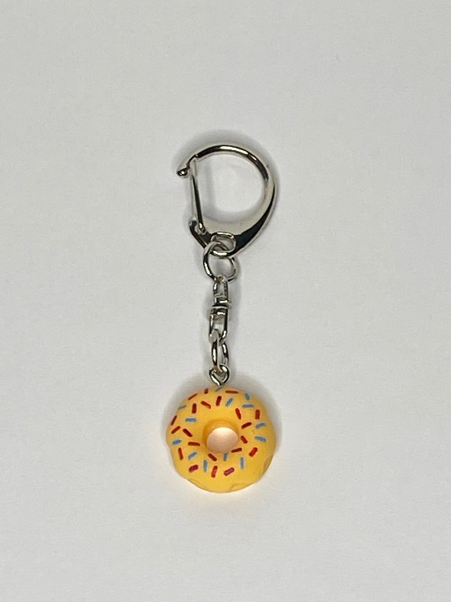 Keychain with a yellow donut charm on a light gray background