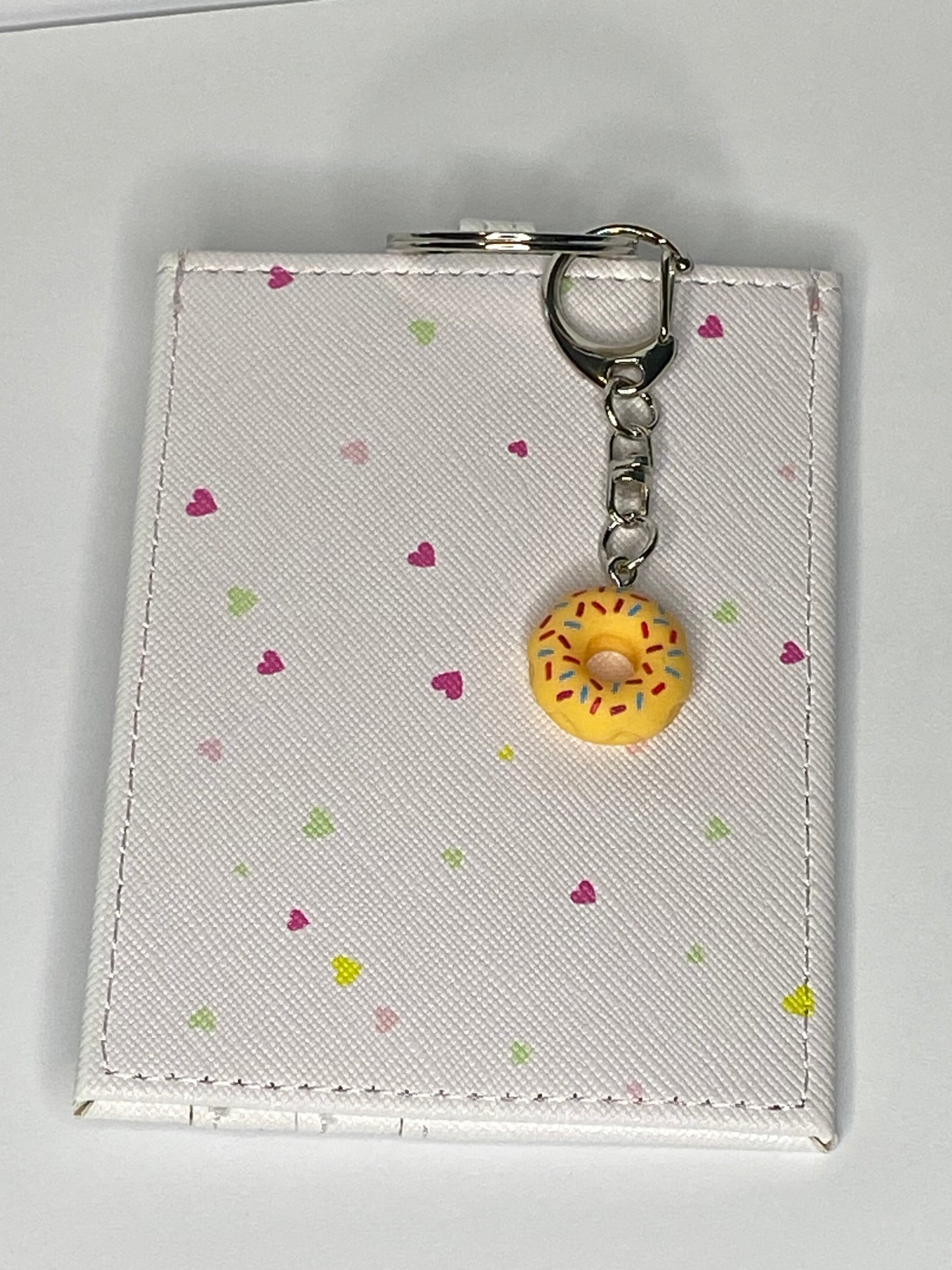 Cardholder with yellow donut keychain on a light gray background