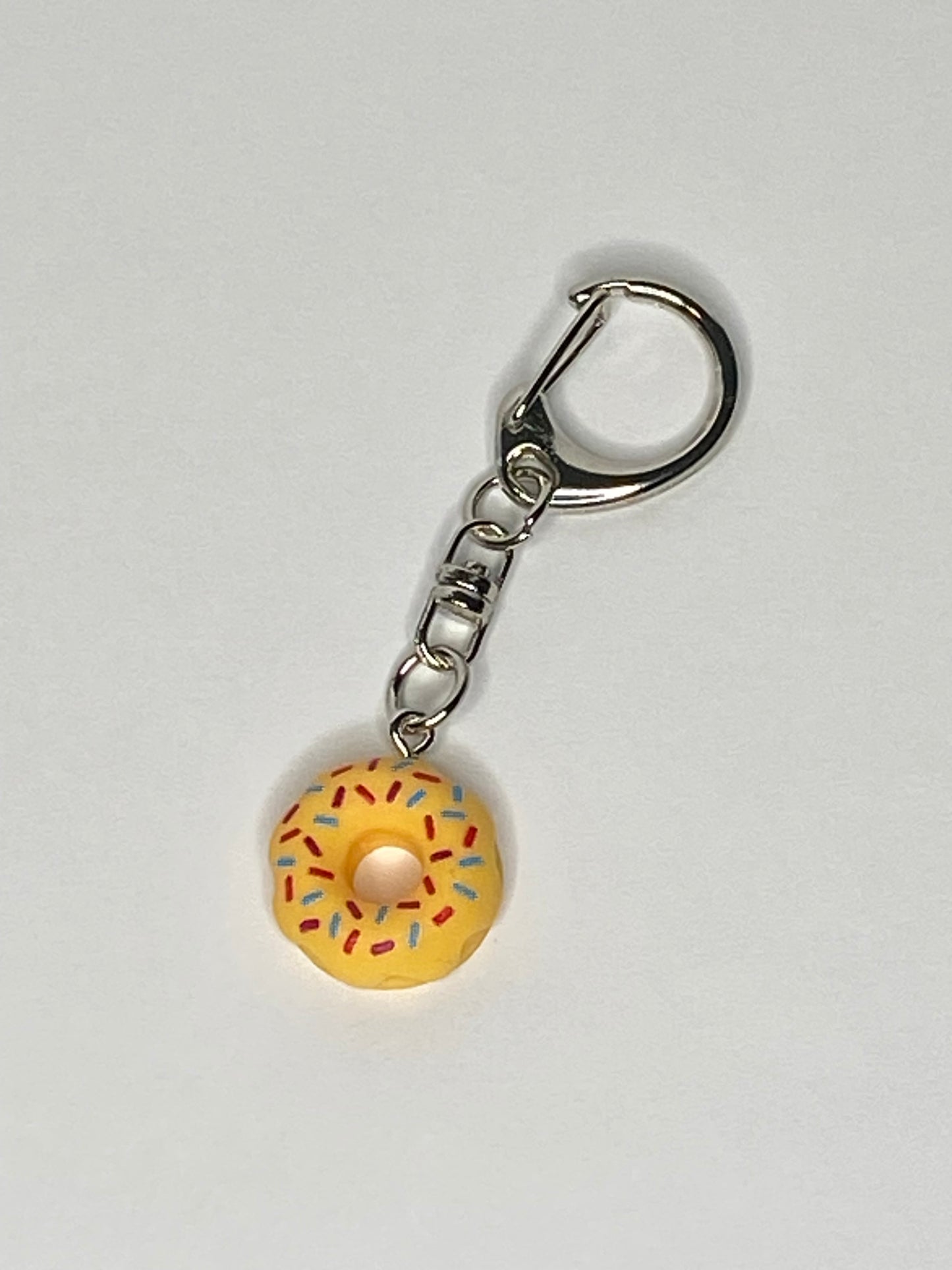 Keychain with a yellow donut charm on a light gray background