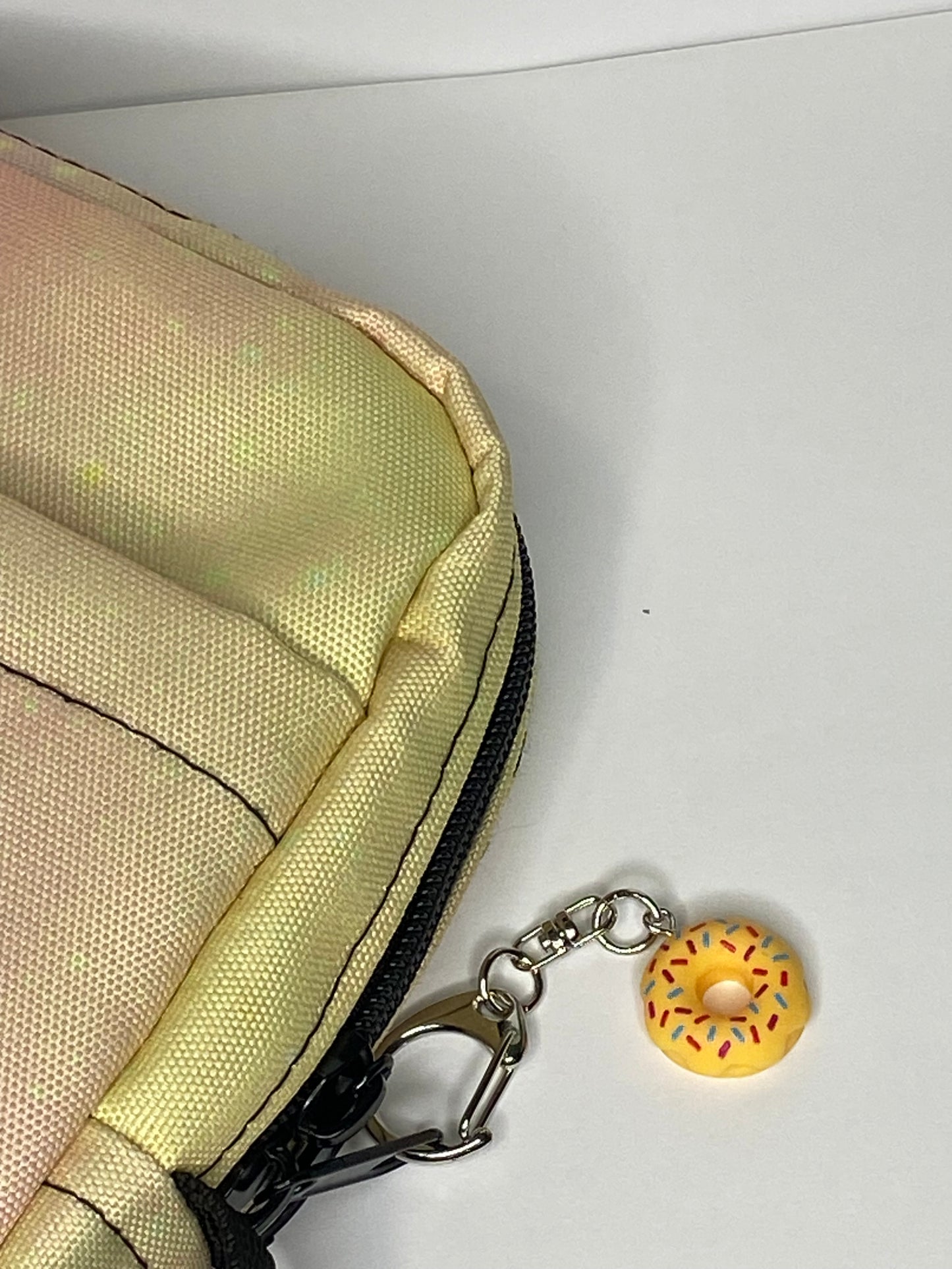 Pastel bag with a donut-shaped keychain on a white background