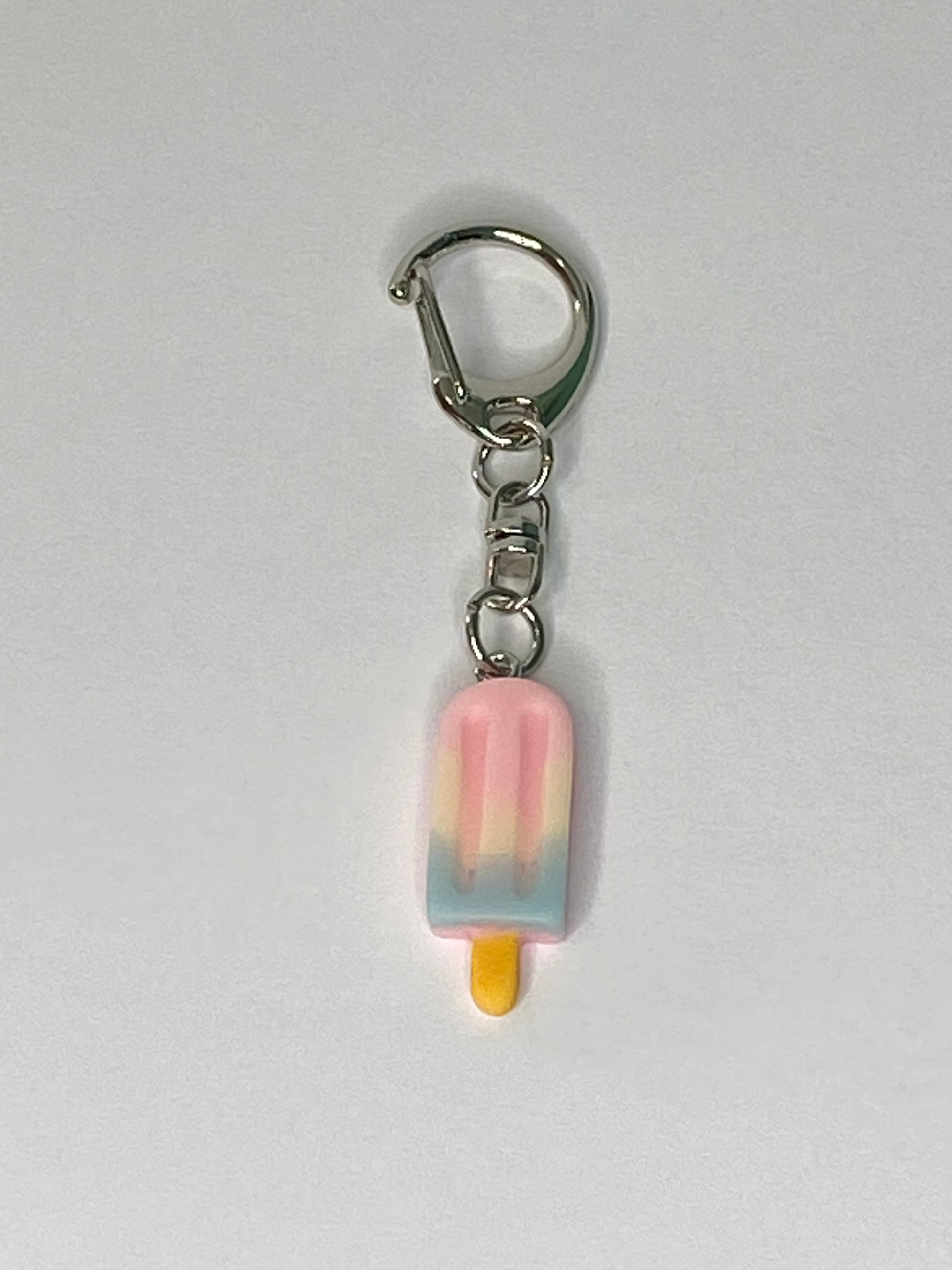 Keychain with a pink popsicle-shaped charm on a light gray background